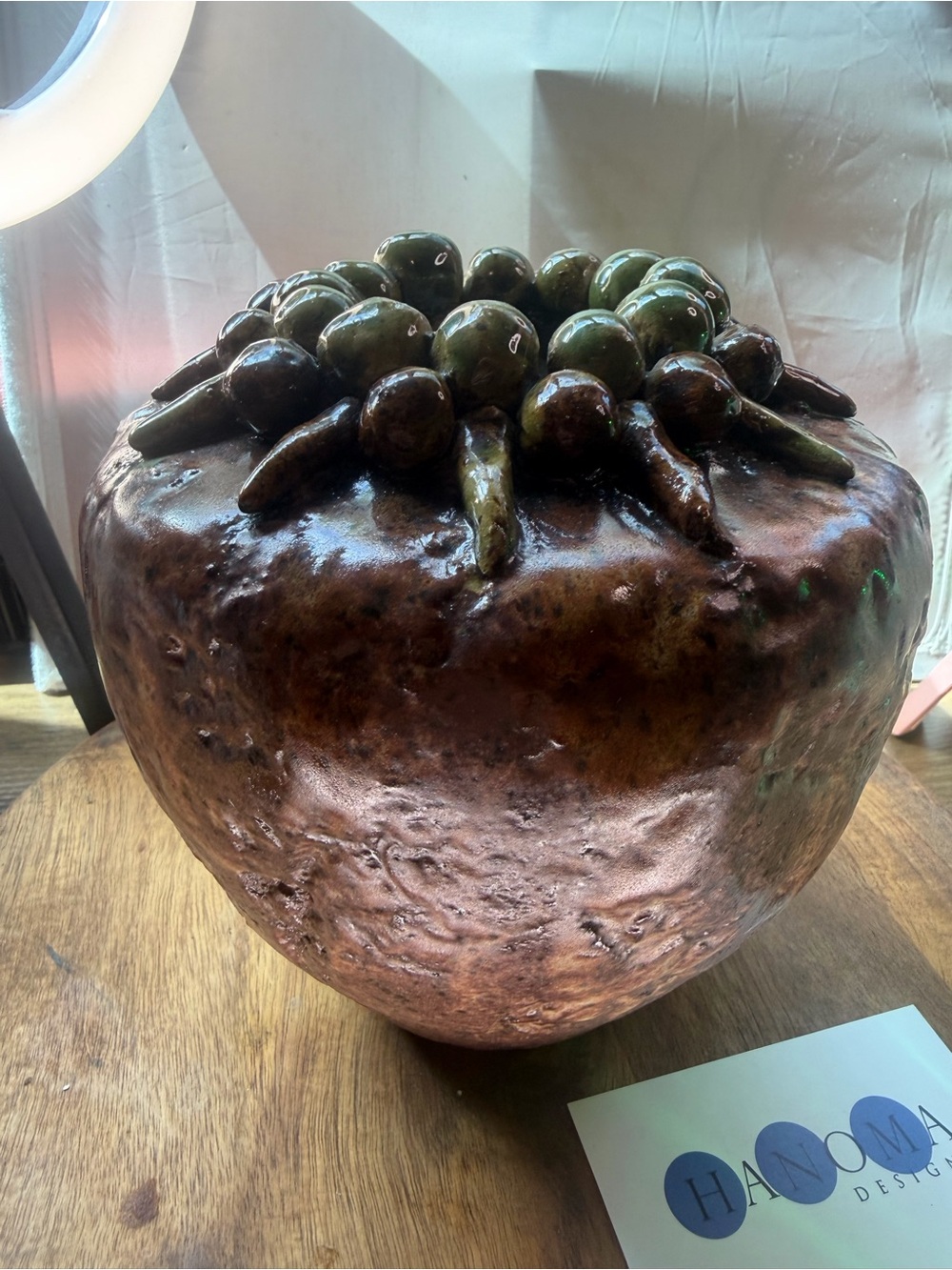A Brutalist style studio pottery vase with acorn and leaf motifs.